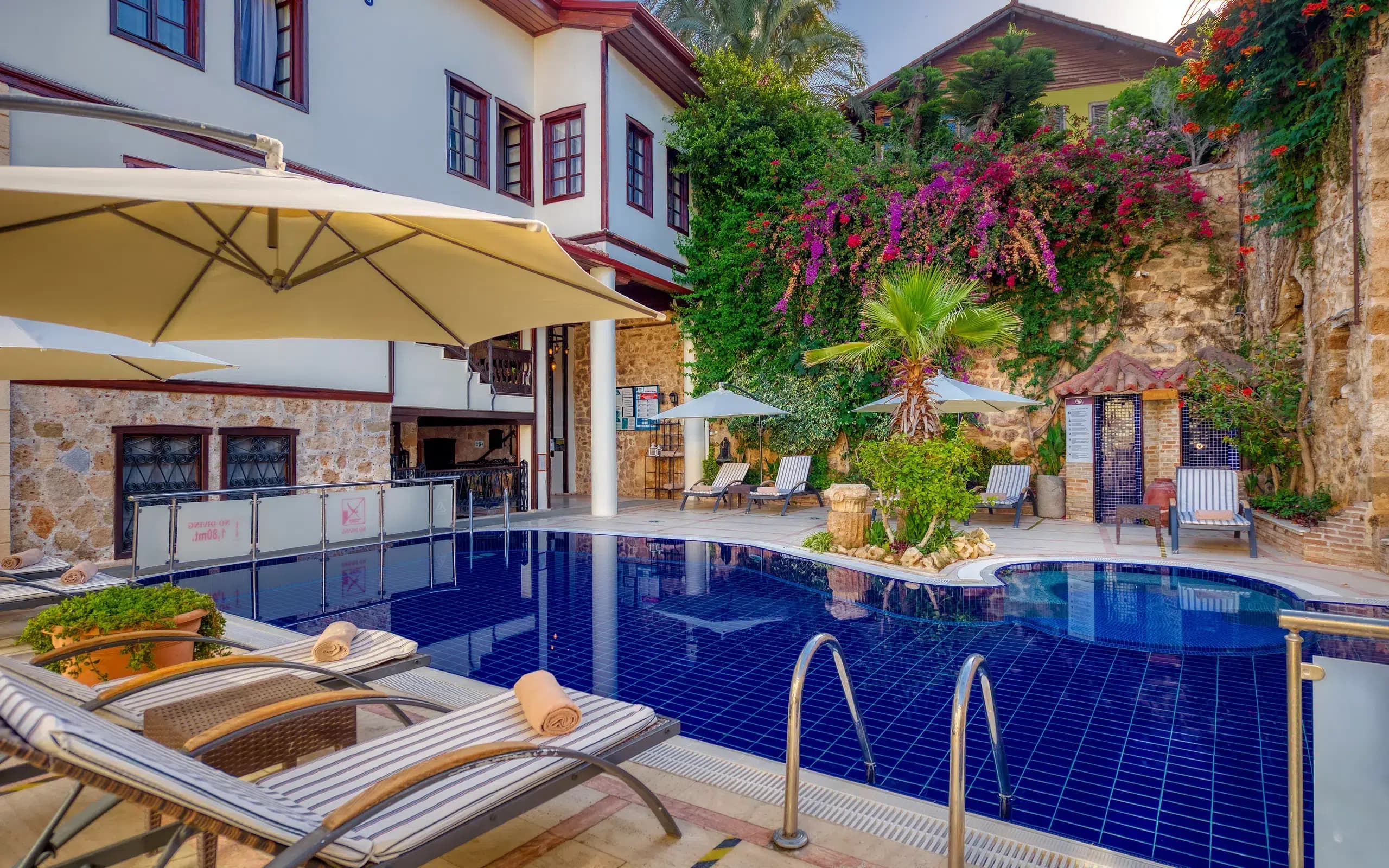 Dogan Hotel Kaleiçi havuzlu taş avlu ve begonviller