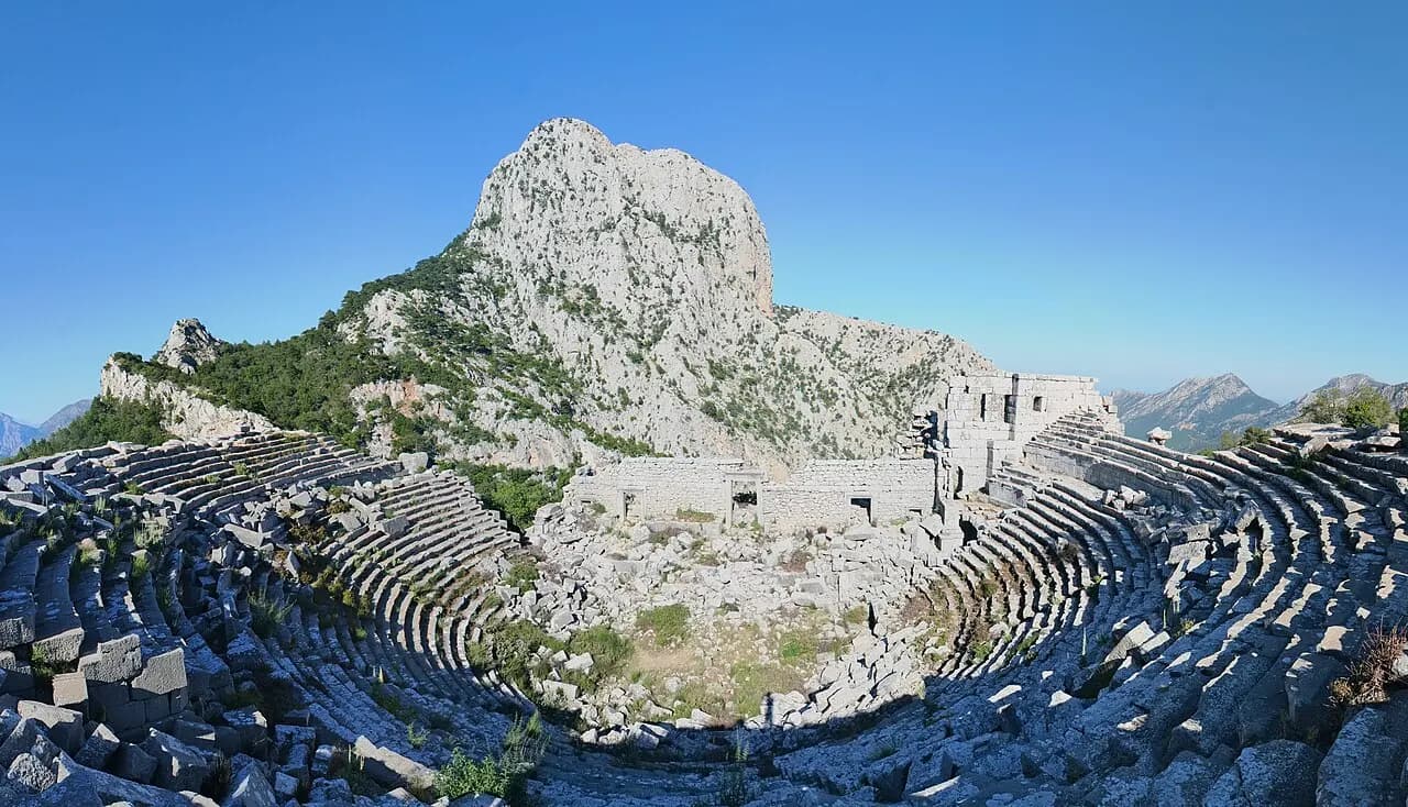 Termessos Antik Tiyatrosu ve arka plandaki Güllük Dağı zirvesi